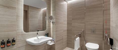 A modern bathroom with a large mirror, a sink, a toilet, and a shower.