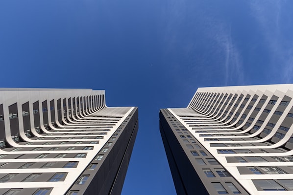 Dos edificios altos con un diseño arquitectónico único que presenta líneas curvas y múltiples ventanales.