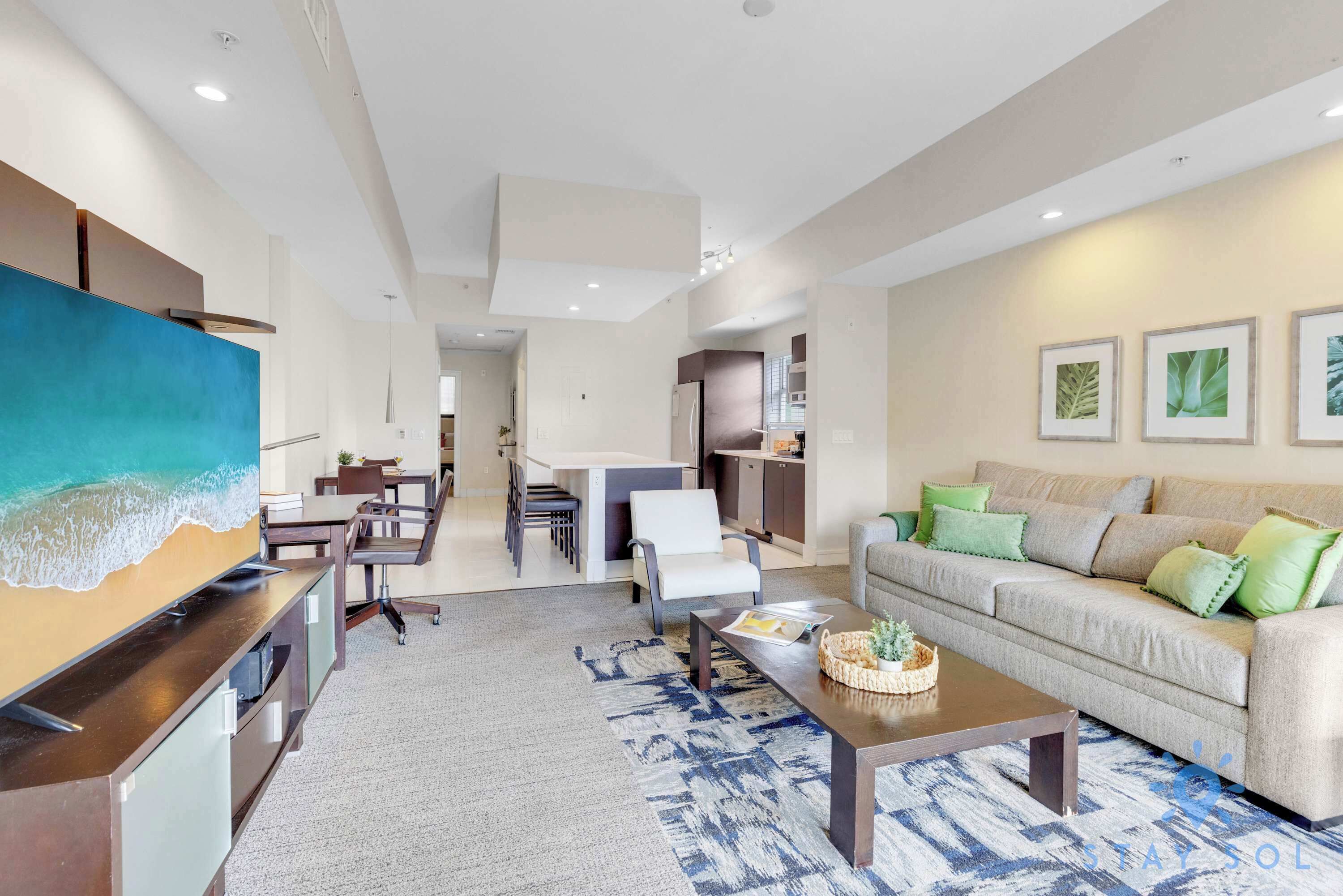 A modern living room with a sofa, coffee table, and artwork on the wall.