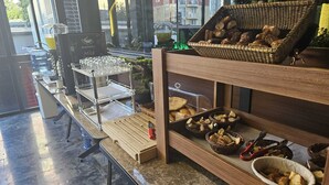 Un angolo colazione con bicchieri, pane e pasticceria.
