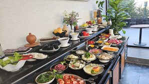 Un buffet con diversi cibi e stoviglie.