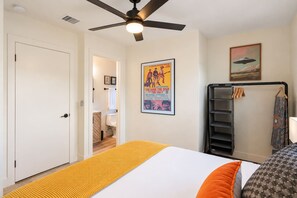 A bedroom with a bed, a ceiling fan, a poster, and a wardrobe. - Uptown Red Rock Retreat | Hot Tub & Patio Views (Sedona)