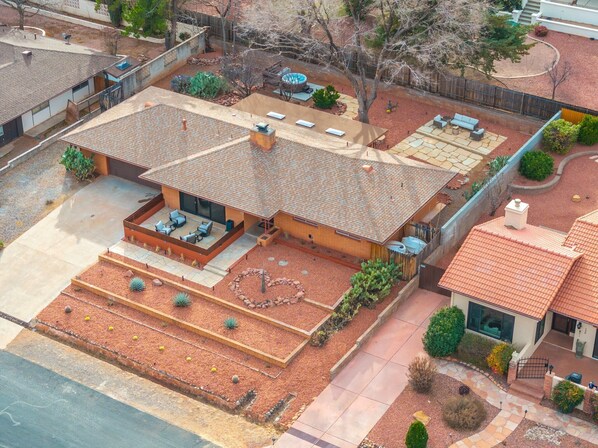 A modern house with a patio, a covered outdoor seating area, and a landscaped garden.
