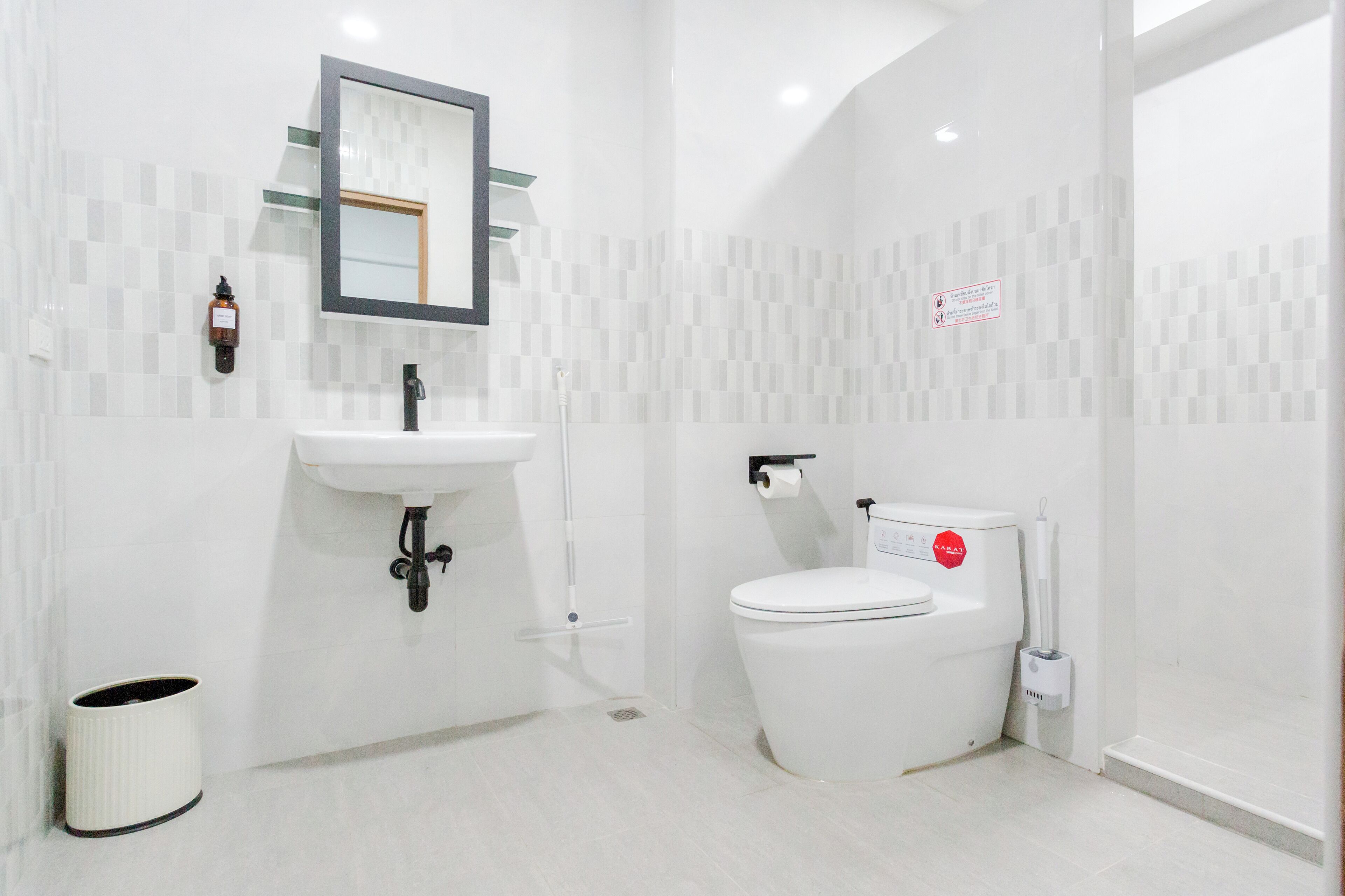 A modern bathroom with a white sink, mirror, and toilet.