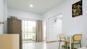 A modern hotel room with a dining area, a refrigerator, and a large window with curtains. - Rama Residency Sukhumvit Bangkok (Bangkok)