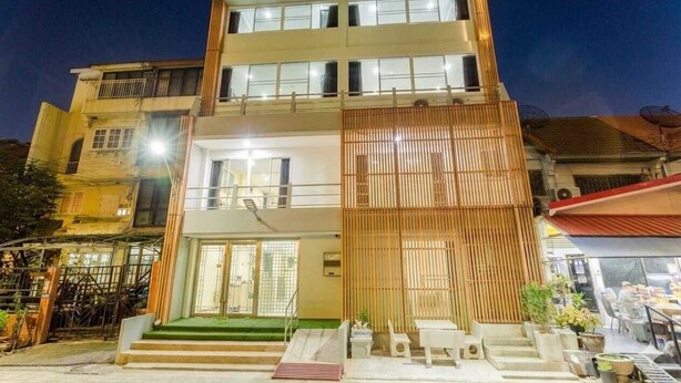 A multi-story building with a balcony, a staircase leading to the entrance, and a covered outdoor seating area. - Rama Residency Sukhumvit Bangkok (Bangkok)