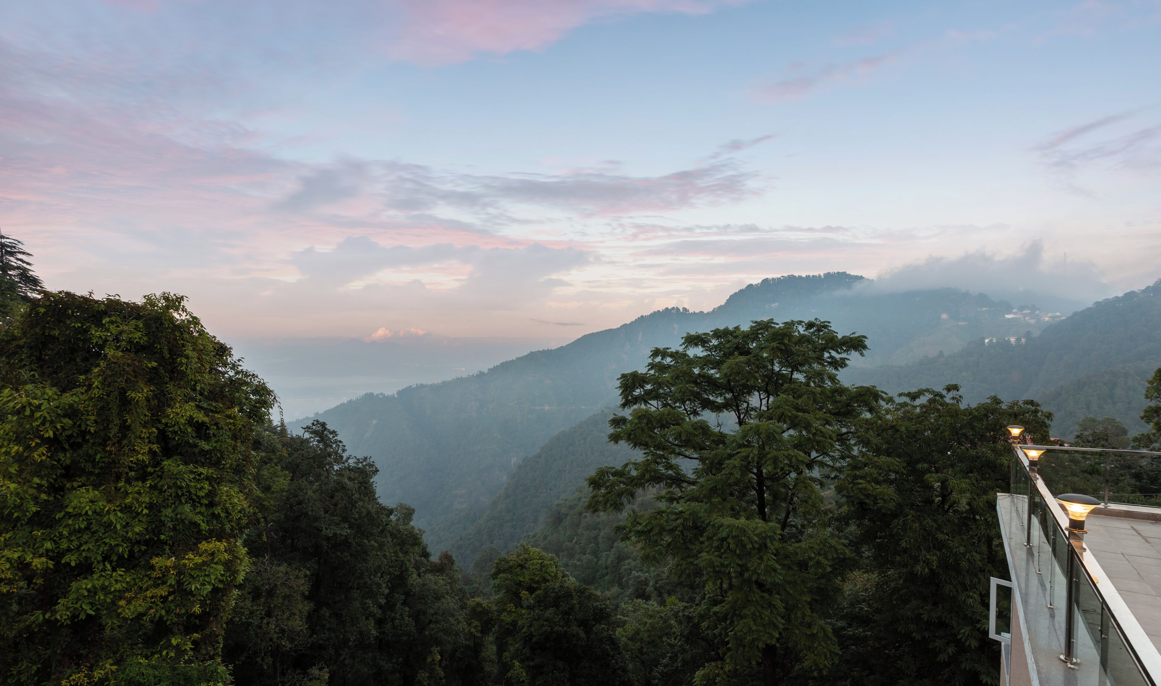 A mountainous landscape with dense forest and a clear sky.