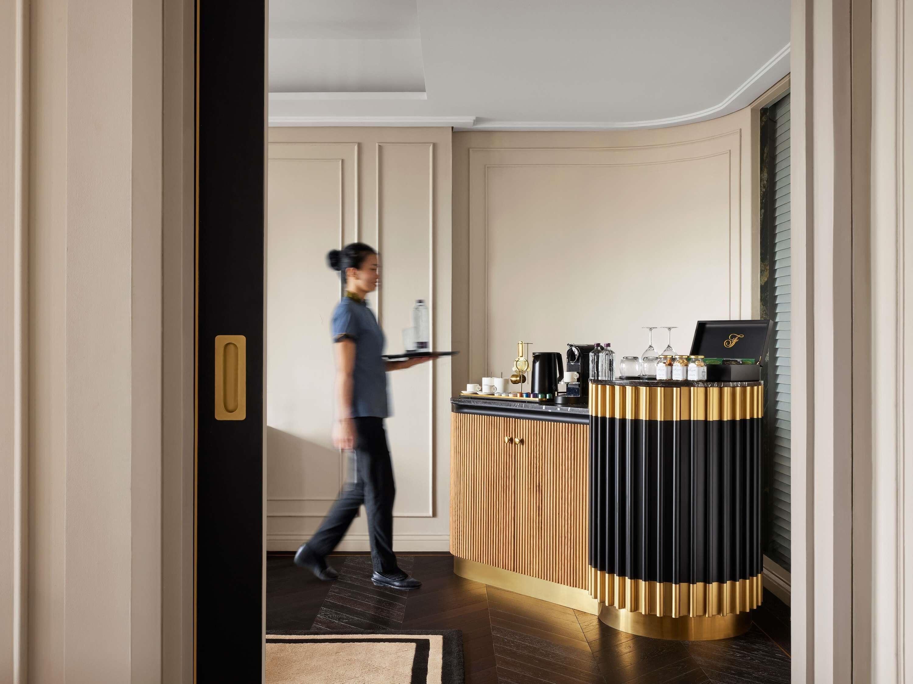 A hotel reception area with a counter, a coffee machine, and a minibar.