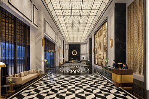 A luxurious lobby with a geometric black and white floor pattern, a central circular design on the floor, and a reception desk with two staff members. - Fairmont Mumbai (Mumbai)
