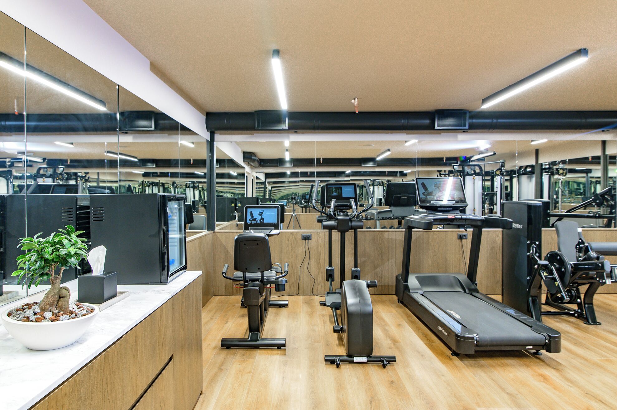 A modern gym with exercise equipment, a treadmill, and a stationary bike.