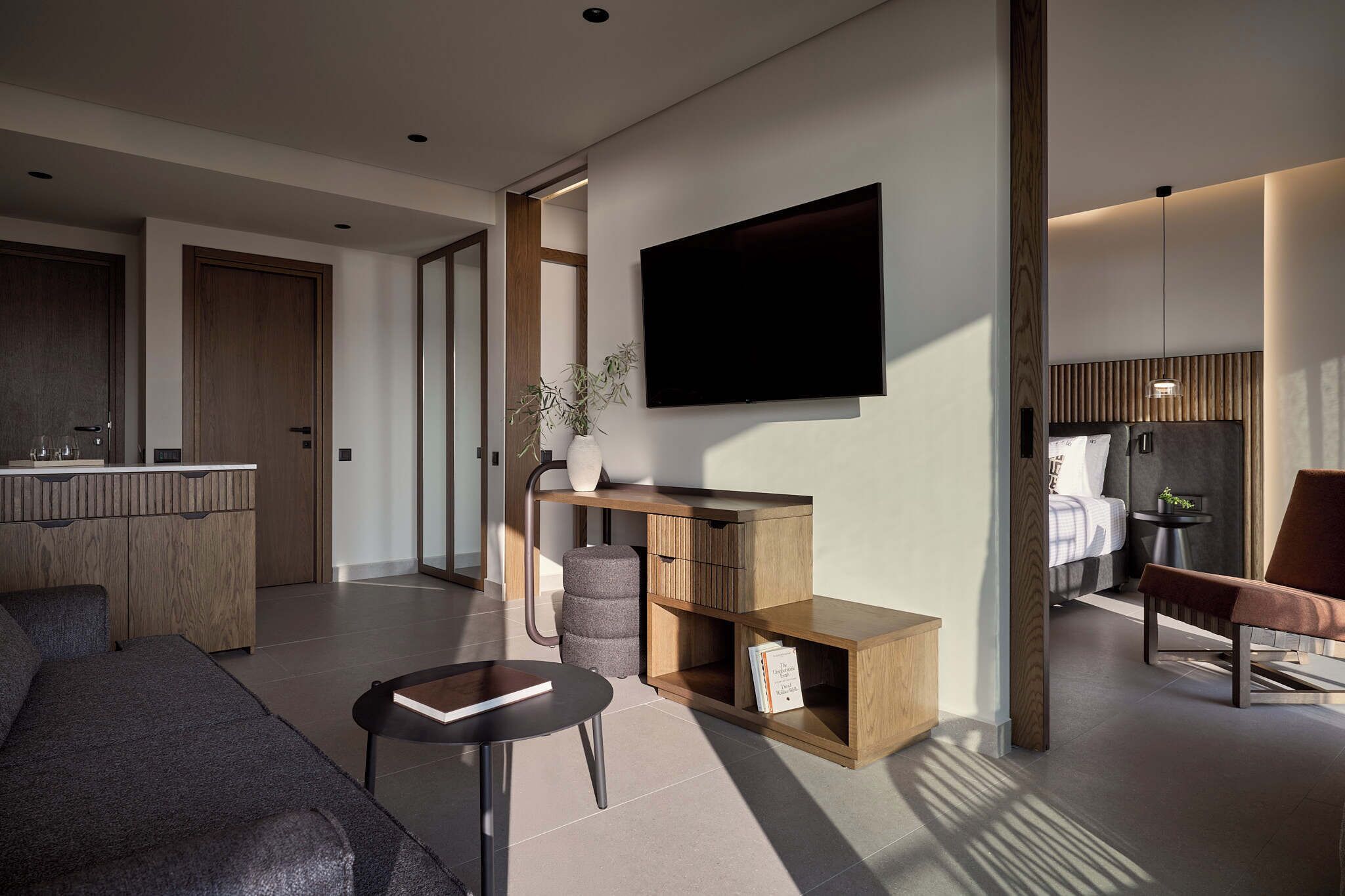 A modern living room with a sofa, coffee table, and a TV mounted on the wall.