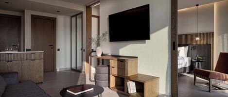 A modern living room with a sofa, coffee table, and a TV mounted on the wall.