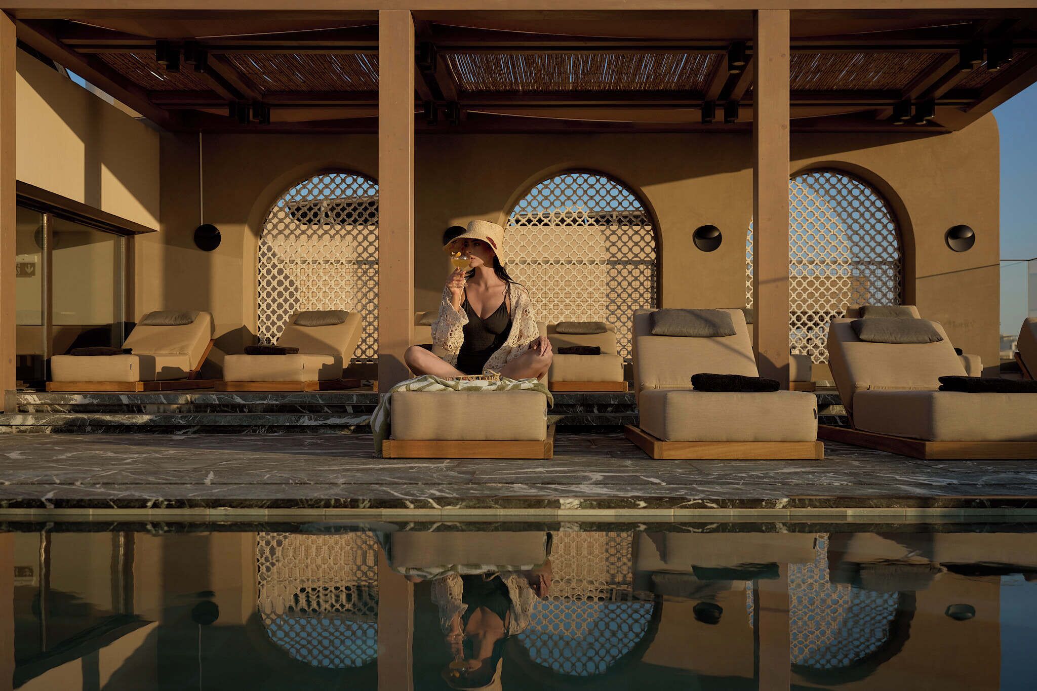 A poolside area with lounge chairs and a person relaxing.