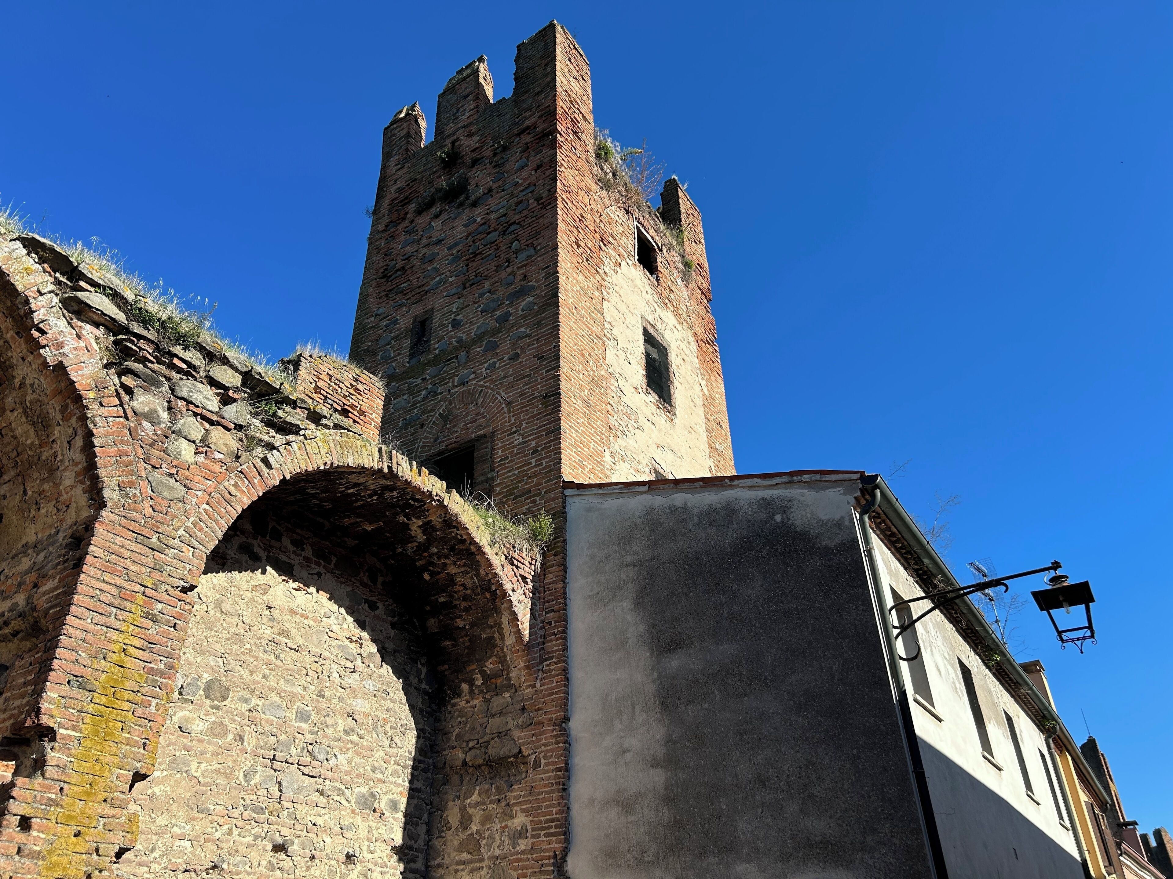 A historic stone tower with a brick archway.