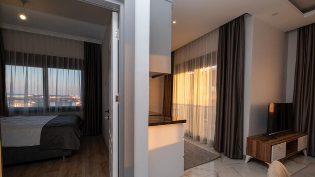 A modern hotel room with a bed, a desk, and a TV.
