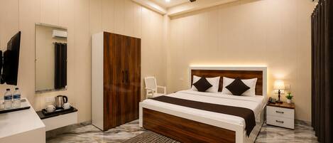 A modern hotel room with a bed, bedside table, nightstand, and a ceiling fan.