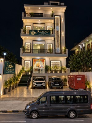 A multi-story hotel with a prominent sign for 'Raghuvan by Aliasvan' and a staircase leading to the entrance. - Raghuvan by Aijasvan (Faizabad)