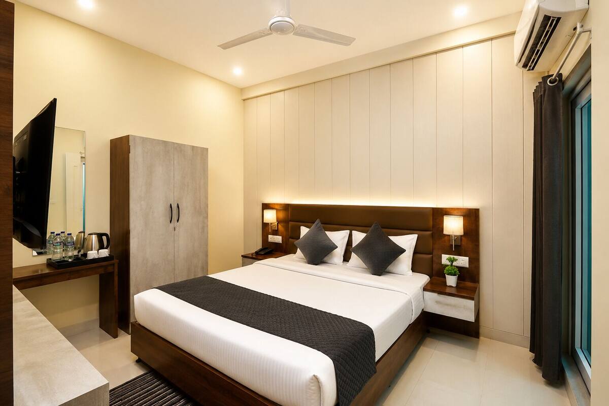 A hotel room with a bed, nightstands, a TV, a wardrobe, and a ceiling fan.