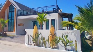 A modern building with large windows, a balcony, and a wall with cactus decorations.