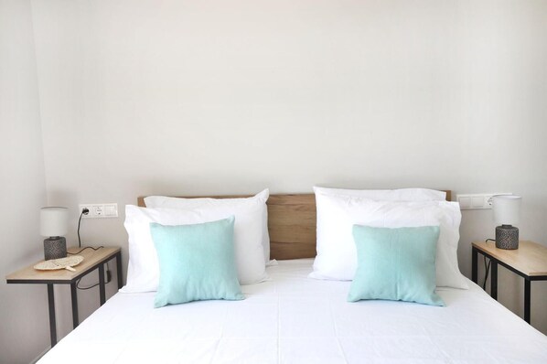 A hotel room with a bed, two bedside tables, and two lamps.