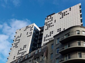 A modern high-rise building with a unique geometric facade, featuring a mix of glass and concrete panels. - Bright & Modern 2BR Apt on Iconic Chapel Street (South Yarra)