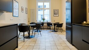 Una cocina moderna con una isla central, electrodomésticos negros y suelo de baldosas.