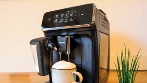 A coffee machine with a cup of coffee and a small potted plant beside it. - Spreewald courtyard - south side with terrace (Unterspreewald)