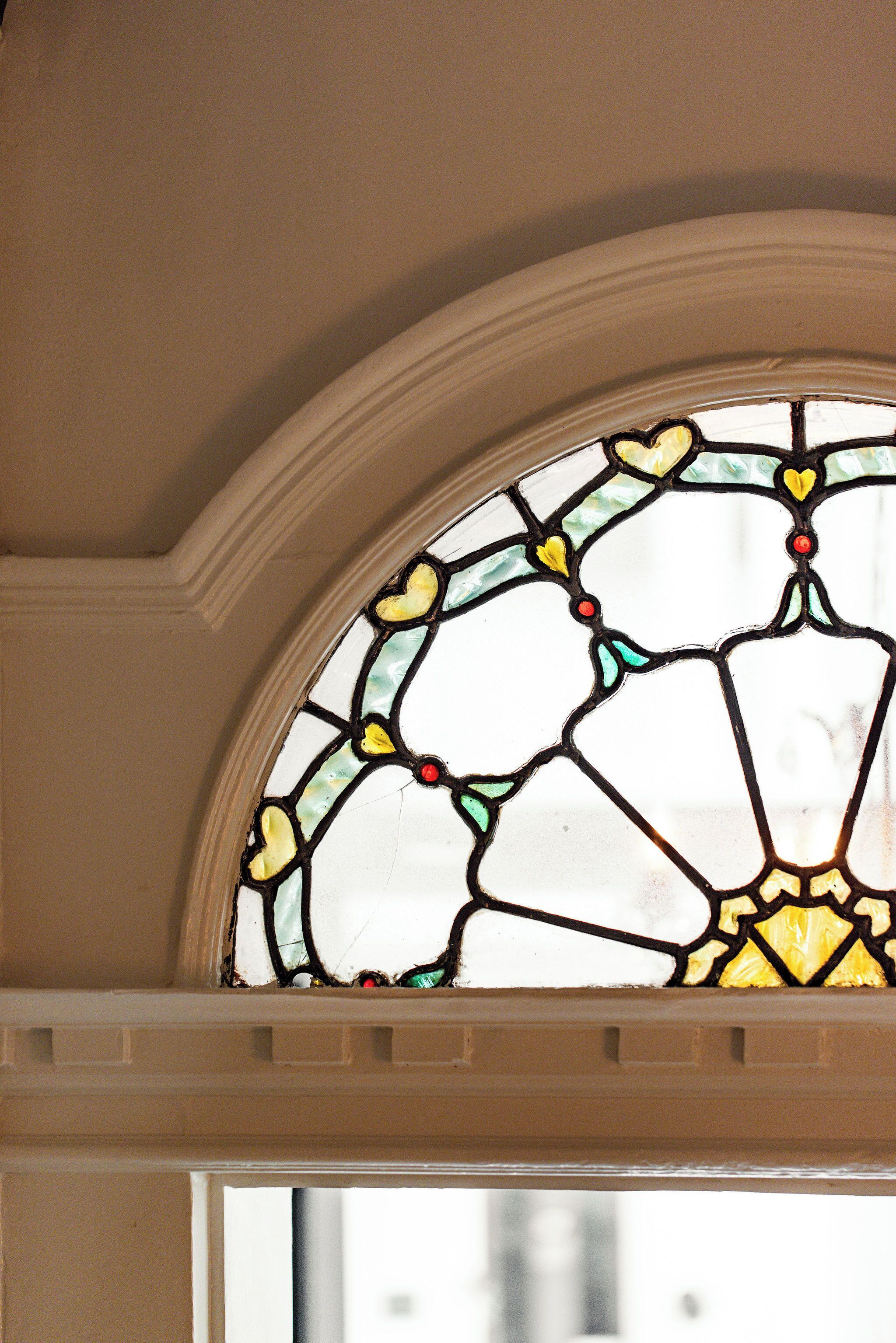 A stained glass window with a geometric pattern and a red dot at the center.