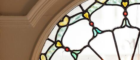 A stained glass window with a geometric pattern and a red dot at the center.