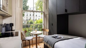 A bedroom with a large window, a bed, a bedside table, and a chair. - FiveM Notting Hill (London)
