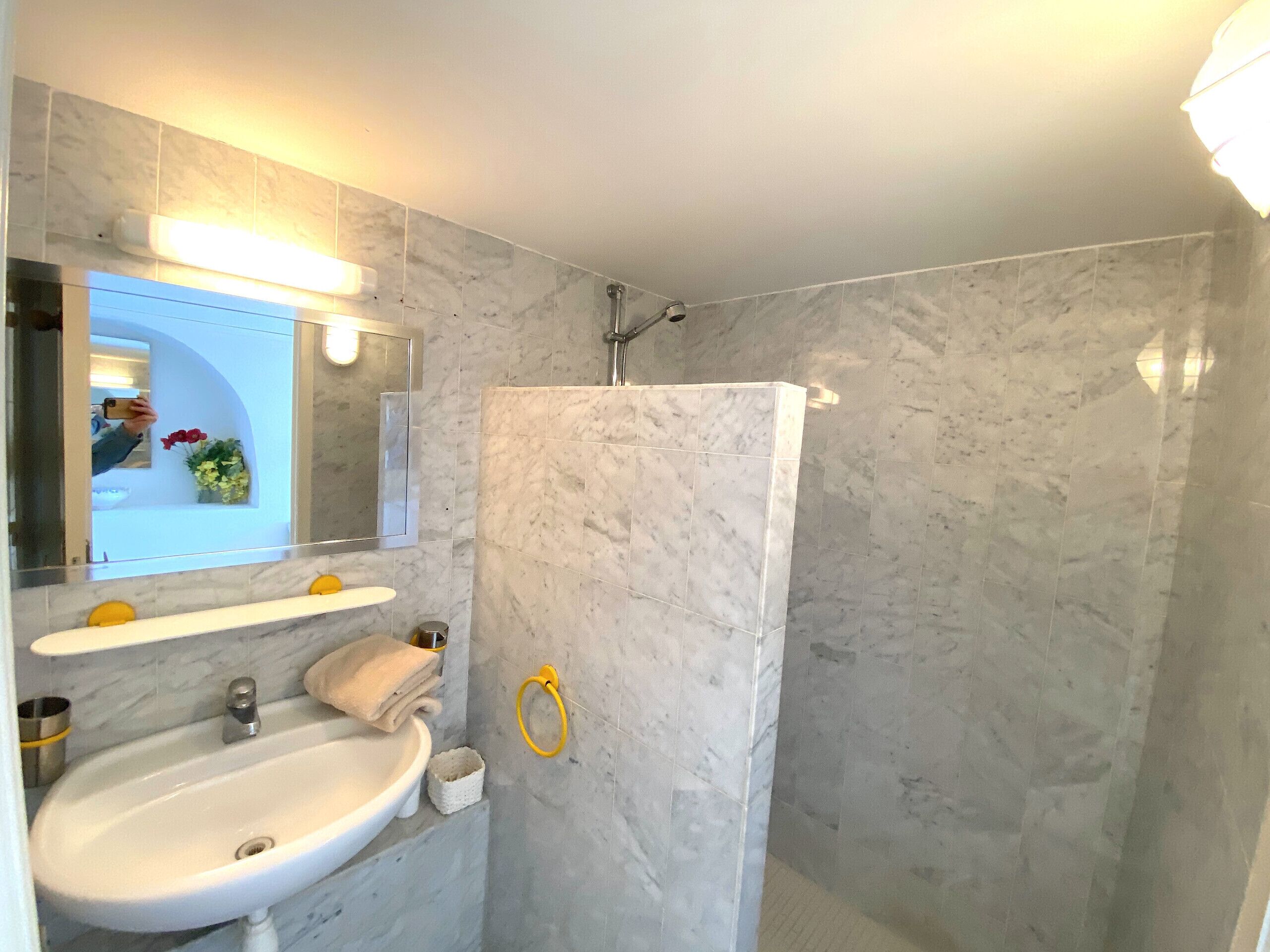 A bathroom with a white sink, mirror, and shower.