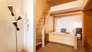 A compact bedroom with a bunk bed, a wooden ladder, a bedside table, and a floor lamp. - ESCALINADA II AP4433  by Riviera Holiday Homes (Villefranche-sur-Mer)