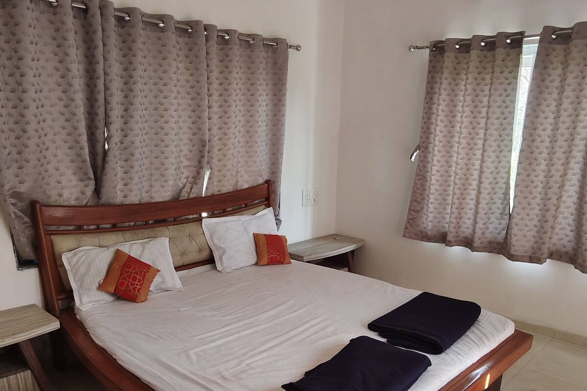 A spacious bedroom with a large bed, a wooden headboard, and a ceiling fan.