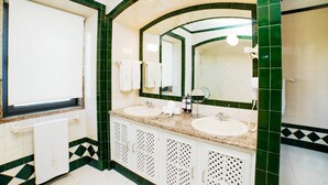 Une salle de bain avec deux lavabos, un miroir et une fenêtre.