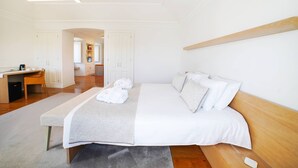 Une chambre d’hôtel équipée d’un lit, d’une table de chevet, d’un bureau et donnant sur le couloir.