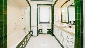 Une salle de bain avec une baignoire, une fenêtre, un lavabo et un miroir.
