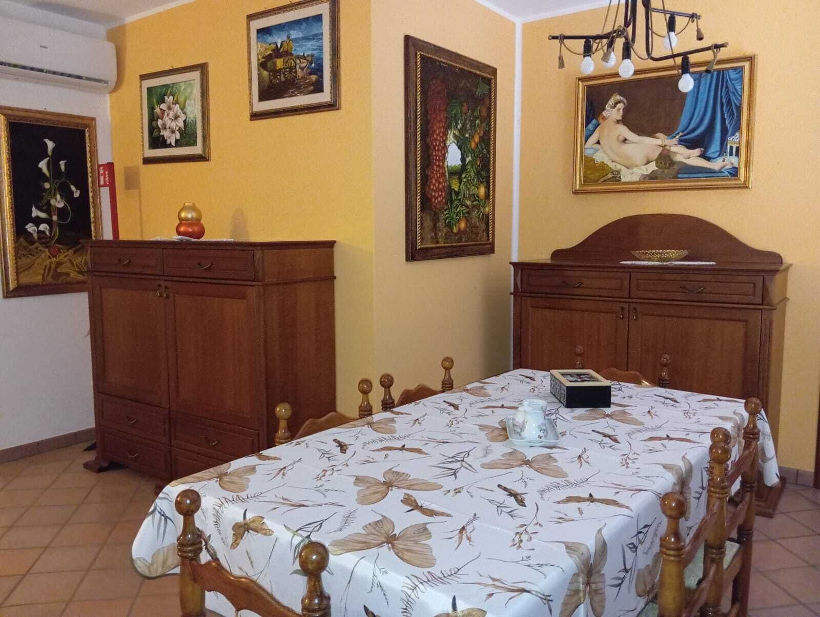 Ein Schlafzimmer mit einem Bett, einem Holzschrank und zwei Bildern an der Wand.