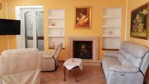 A living room with two sofas, a fireplace, and a television. - La Mery Giò House (Fasano)