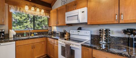 A kitchen with wooden cabinets, a microwave, a stove, and a coffee maker.