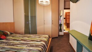 Ein Schlafzimmer mit einem Bett, einem Kleiderschrank und einem Spiegel.