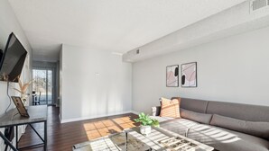 A modern living room with a sofa, coffee table, and artwork on the wall.