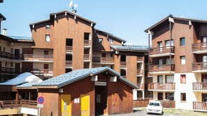 A multi-story wooden building with balconies, a sign reading "LE ROY BLANC," and a no parking sign. - Cozy apartment at the slopes with balcony (Val Thorens)