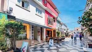 A street with cafes, shops, and a tiled pavement. - Seaside Modern Flat II at Cascais (Cascais)