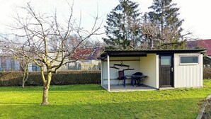 Ein kleines, eingeschossiges Gebäude mit einer überdachten Terrasse.
