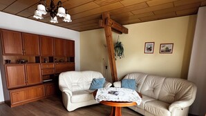 Ein Wohnzimmer mit Holzboden, einer Couch, einem Couchtisch und Holzschränken.