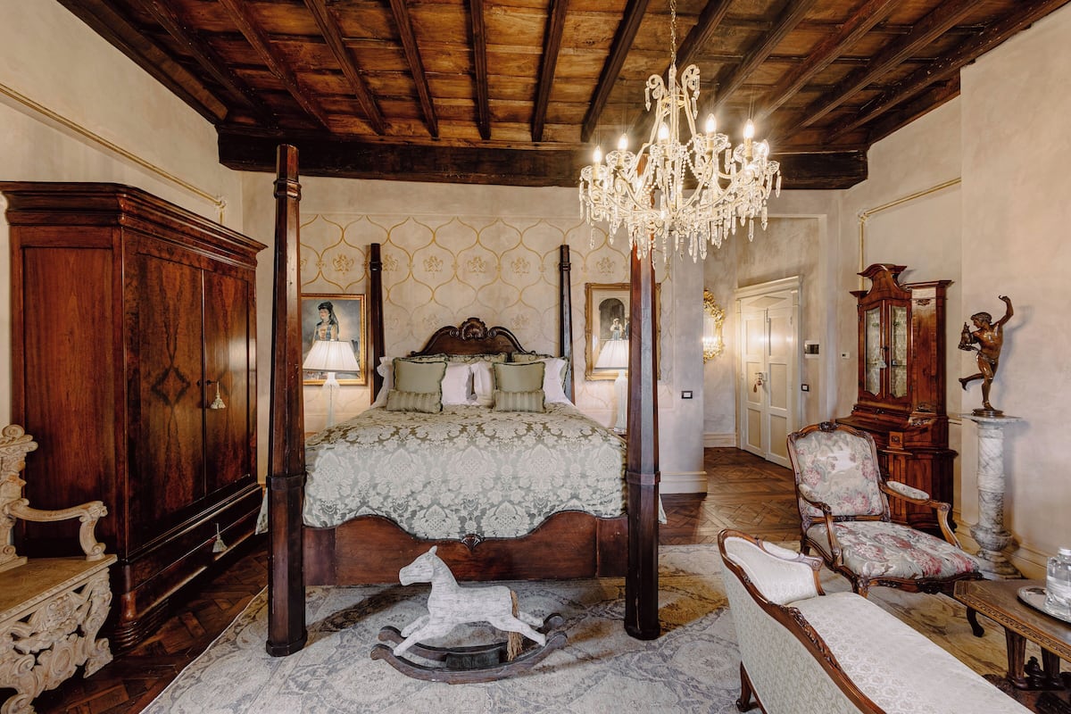 Ein geräumiges Schlafzimmer mit einem großen Bett, Holzmöbeln und einer Kronleuchter.