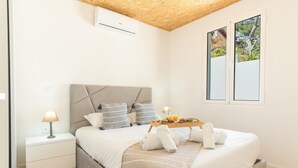 Quarto com cama, mesas de cabeceira, bandeja de café da manhã e janela com vista.
