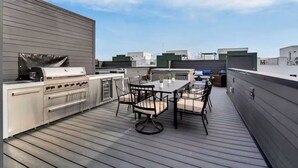 En takterrass med en inbyggd grill och ett matområde.