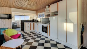 Uma cozinha moderna com piso xadrez, armários de madeira e forno embutido.