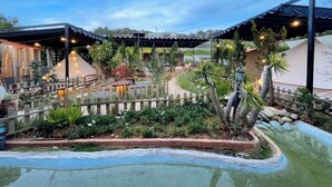 A resort with outdoor seating areas, a swimming pool, and a landscaped garden. - The Monhi Da Lat (Xuan Huong - Da Lat)